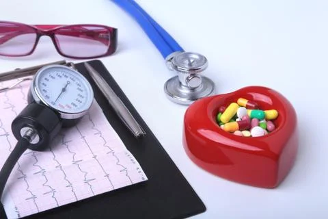 Red heart, asorted pils, glasses and a stethoscope on white background. Stock Photos
