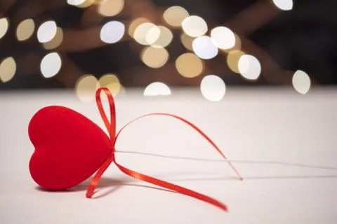 Red heart with a bow lying on a table with bokeh Stock Photos