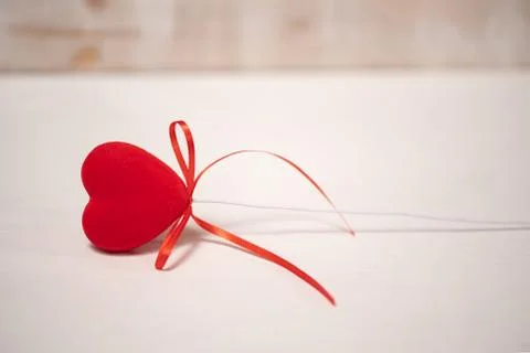 Red heart with a bow lying on a table Stock Photos