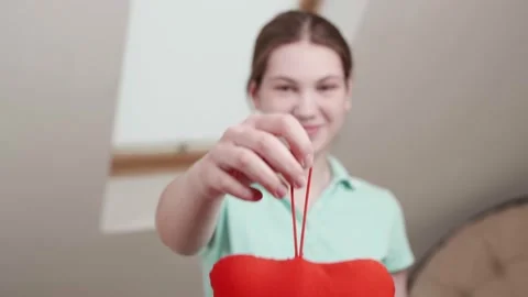 Red heart close up in hands of smiling caucasian teenager on Valentines Day. Vidéo 145990197