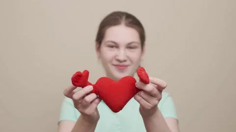 Red heart close up in hands of smiling caucasian teenager on Valentines Day. Vidéo 145990201