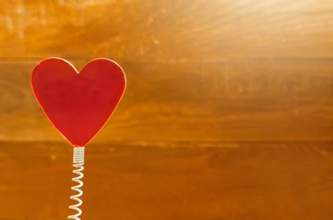 Red Heart On Coil Spring. Rustic Wooden Background. Saint Valentines Day Foto stock