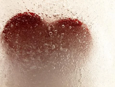 Red heart embedded in ice. Stock Photos