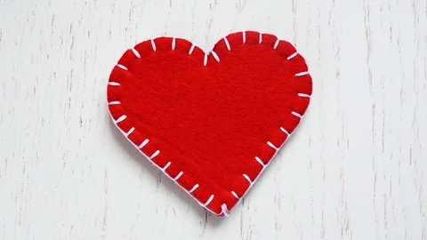 Red heart of felt is lined with white threads Stock-Footage 85751614