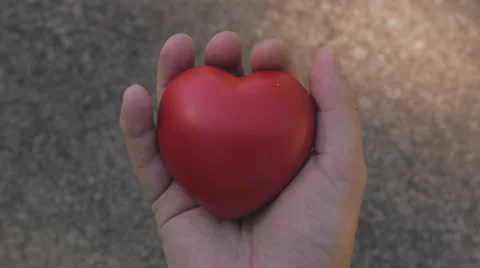 Red heart gets squeezed by hand like it is pumping Stock-Footage 53353841