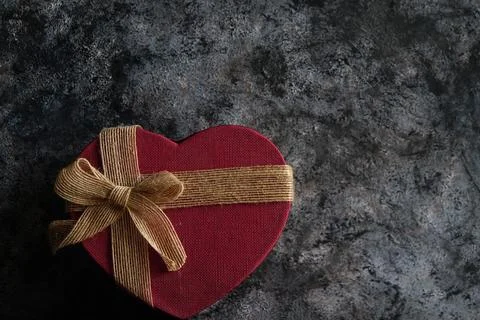 Red heart gift box in front of black background Stock Photos