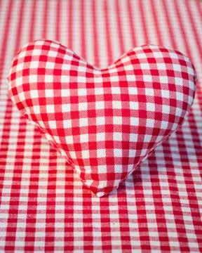 Red heart on gingham tablecloth Stock Photos