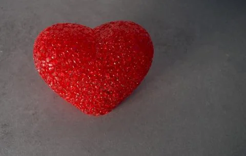 Red heart on grey background, texture of concrete. Stock Photos