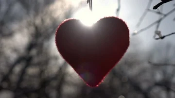 Red heart, hanging in back light, waving and turning. Video stock 86042474