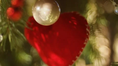 A red heart hanging on the tree among glass balls and garlands heralds the Stock Footage 296402068