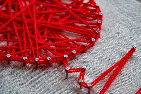 Red heart with heartbeat pulse string art made with tangled yarn on metal nails Stock Photos