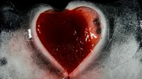 Red heart in ice melting, bleeding Stock Footage