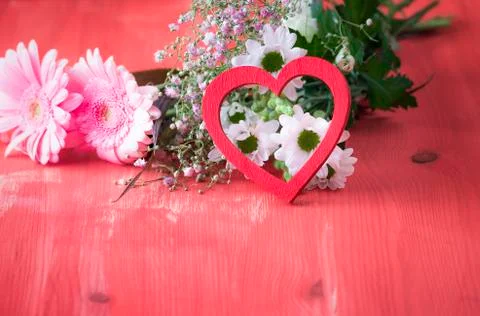 Red heart leaned on flowers Stock Photos