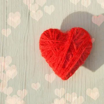 Red heart made of wool threads on a light wooden background Stock Photos