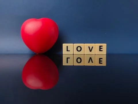 Red heart object and scrabble-style letter tiles that spell the word LOVE Stock Photos
