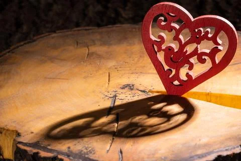Red heart with a pattern on a cracked sawn tree with bark Stock Photos
