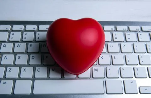 Red heart on pc keyboard of notebook website close up Stock Photos