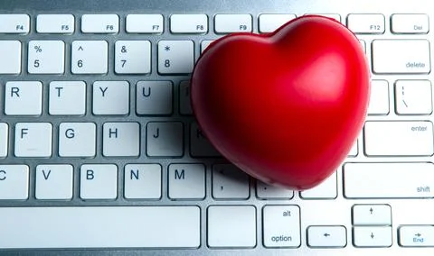 Red heart on pc keyboard of notebook website top view Stock Photos