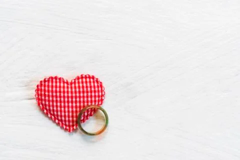 Red heart with ring on white table with free copy space for text. Love, weddi Stock Photos