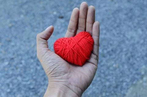 Red heart shape made from thread yarn on Hand for Love Valentine's day Stock Photos