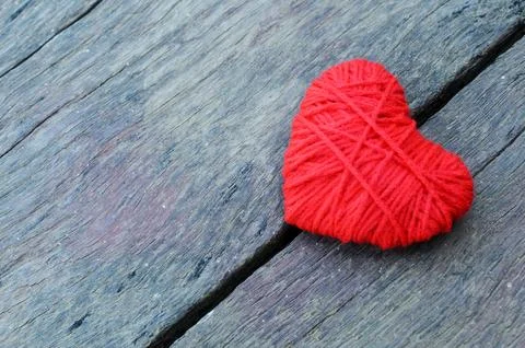 Red heart shape made from thread yarn on old wooden background for Valentin.. Foto stock