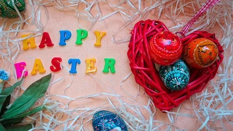 Red heart-shaped basket with Easter eggs &amp; words "Happy Easter" Stock Footage 103852244