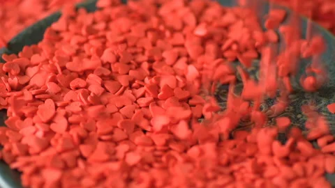 Red heart shaped confetti fall on green plate Stock Footage 146749979