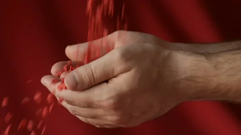 Red heart shaped confetti fall in man's hands Stock Footage 147033337