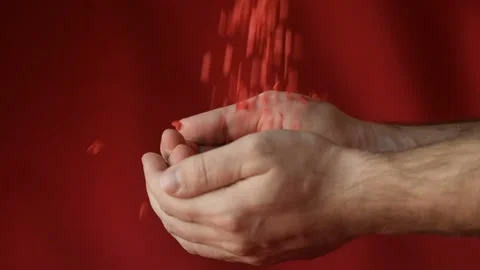 Red heart shaped confetti fall in man's hands Stock Footage 147033503