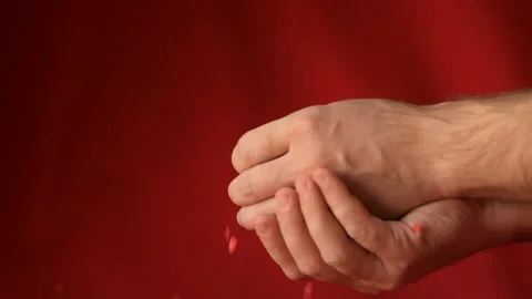 Red heart shaped confetti fall in man's hands Stock Footage 147034172