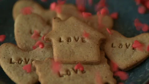 Red heart shaped confetti fall on love cookie Stock Footage 147036982