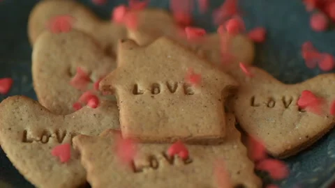 Red heart shaped confetti fall on love cookie Stock Footage 147037012