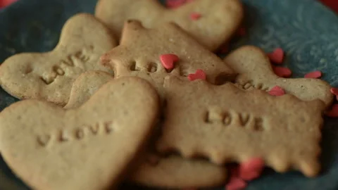 Red heart shaped confetti fall on love cookie Stock Footage 147037266