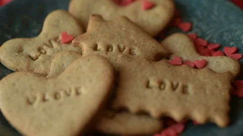 Red heart shaped confetti fall on love cookie Stock Footage 147037343