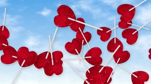 Red Heart Shaped Lollipops Falling Through Blue Sky with Clouds Stock Footage 346116172