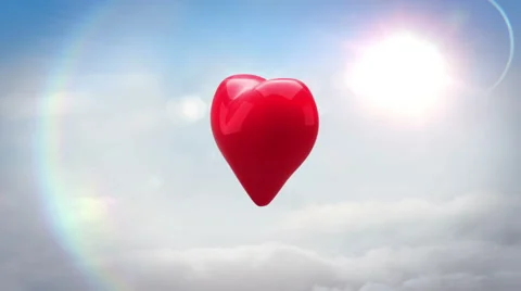 Red heart turning and exploding over blue sky Stock Footage 45374856
