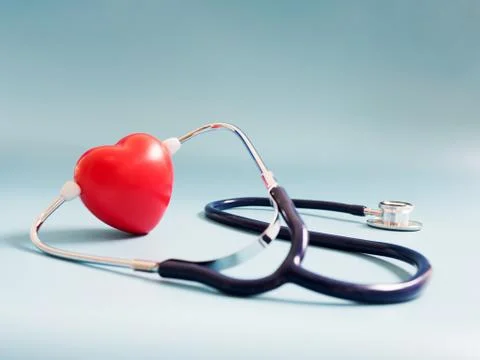 Red heart using deep blue stethoscope on the blue background. Concept of love Stock Photos