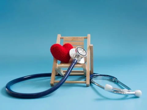 Red heart using deep blue stethoscope on the blue background. Concept of love Stock Photos