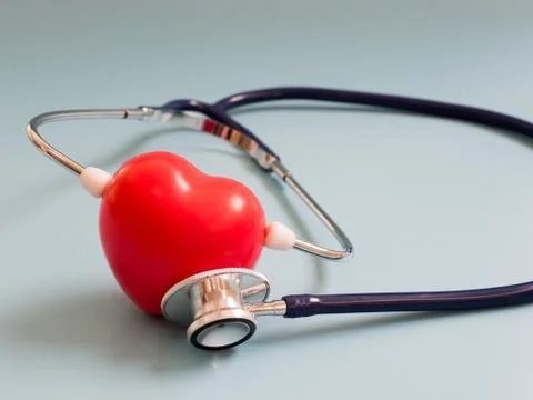 Red heart using deep blue stethoscope on the blue background for hear their o Stock Photos