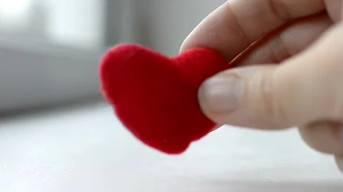 Red heart in woman's hand on grey background. The concept of charity, love Stock Footage 257049105