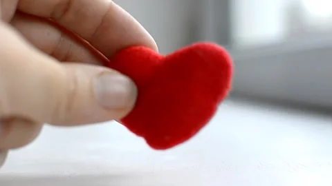 Red heart in woman's hand on grey background. The concept of charity, love Stock Footage 264156545