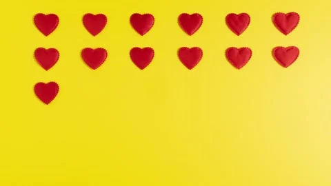 Red hearts float gently across a bright yellow background Stock Footage 294101289