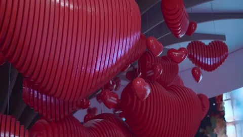 A red hearts, hanging from the ceiling and symbolizing love, kindness and peace Stock Footage 323969476