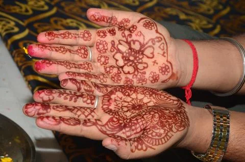 Red heena applying on the hands with design 스톡 사진