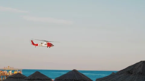 Red Helicopter Flies Low Over The Sea Near The Beach In The Tropics.. 4K Video Stock Footage 121702729