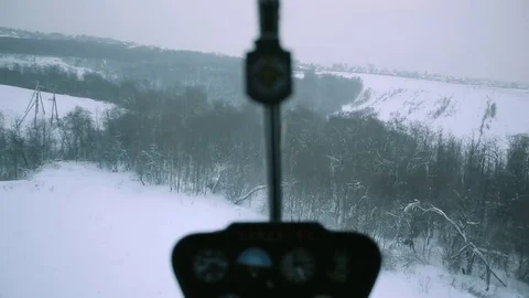 A red helicopter is flying over a snowy forest. Stock Footage 80319136