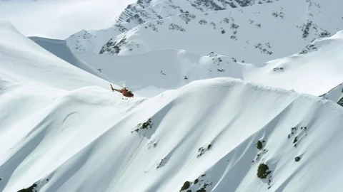 Red helicopter flying over snowy mountains and frosty hills, Iceland Stock Footage 124231256