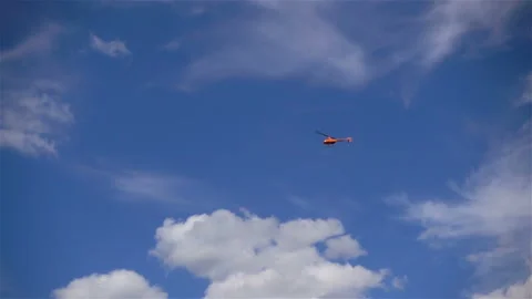 Red helicopter flying in slow motion Stock Footage 135528650