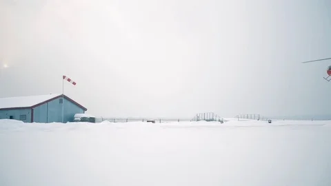 A red helicopter sits on a snow-covered field. Stock Footage 80319112