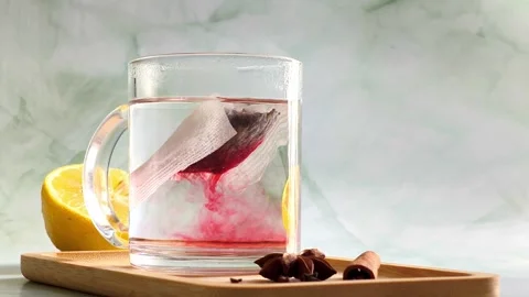 Red herbal tea infusion in clear glass cup with hot steam Stock Footage 336953470